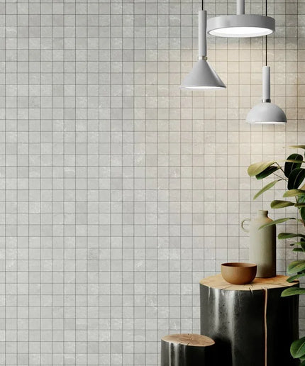 Modern interior with gray square tiles, pendant lights, and a plant.