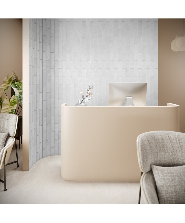 Modern office reception area with a beige desk and gray chairs.