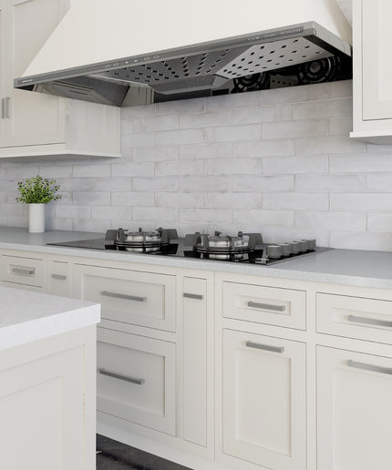 Modern kitchen with white cabinets, gray countertop, and stainless steel range hood.