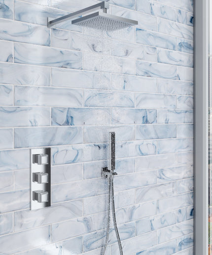 Shower setup with tiled wall featuring a modern shower head and control panel.