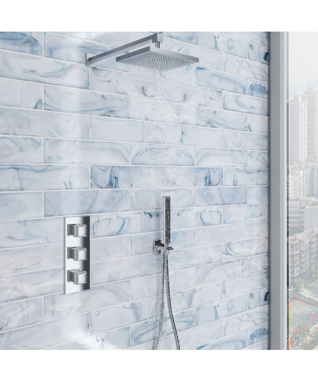 Shower setup with tiled wall featuring a modern shower head and control panel.