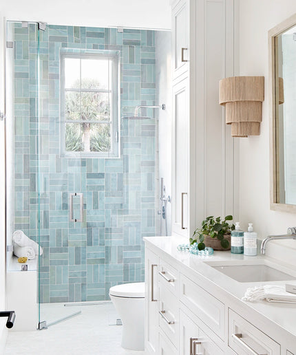 Modern bathroom with glass shower door, vanity, and mirror.