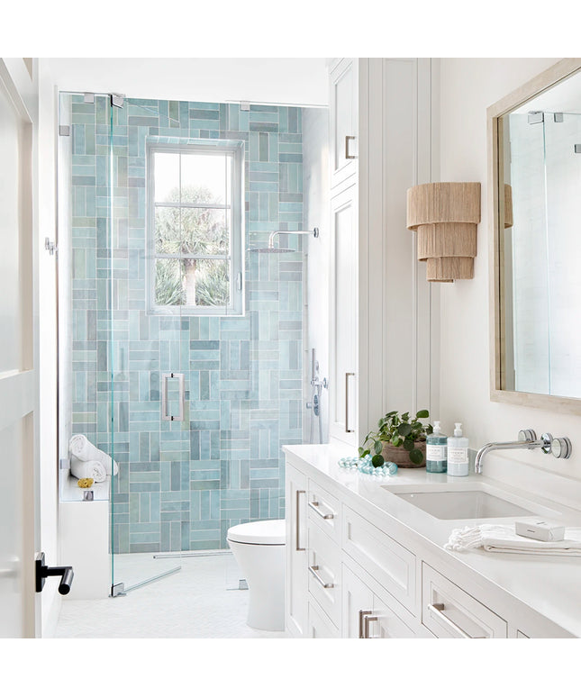 Modern bathroom with glass shower door, vanity, and mirror.