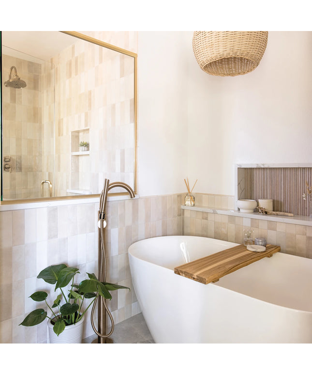 Modern bathroom with a freestanding bathtub, wooden tray, and decorative elements.