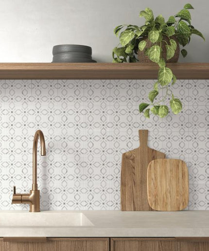Modern kitchen with a sink, wooden cutting board, and plant on a shelf.