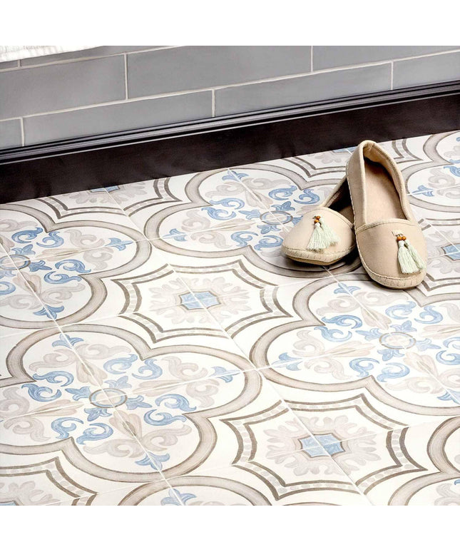 Decorative tiles with a geometric pattern on a floor, featuring two beige shoes with tassels.