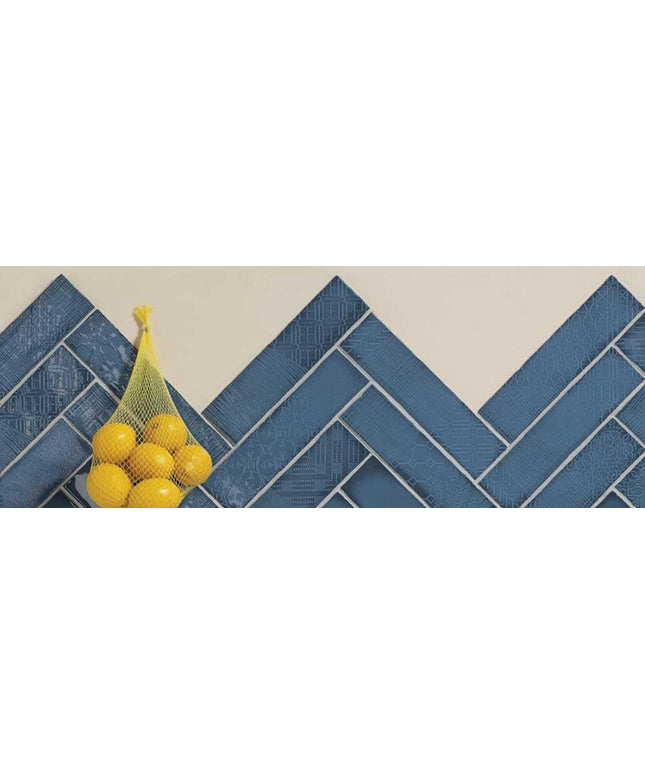 Bag of lemons and a banana on a blue tiled floor herringbone design
