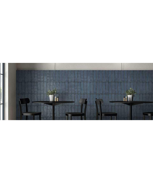 Modern interior with black tables and chairs against a blue tiled wall.