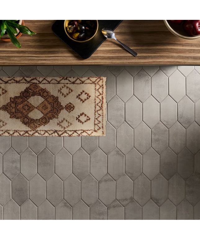 Hexagonal tile floor with a small rug on a wooden surface