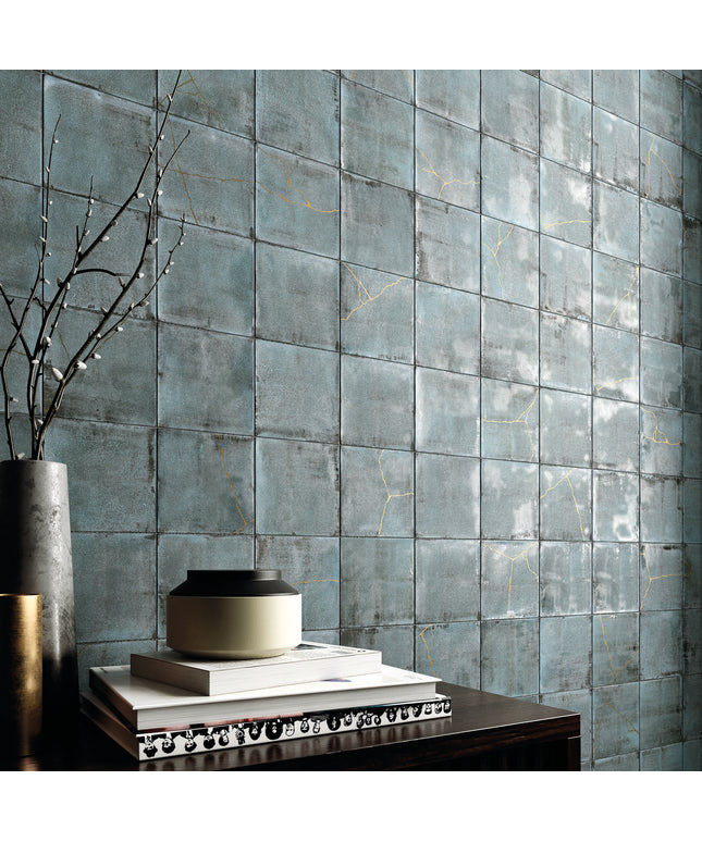 Decorative teal tiles with a vase and books on a table