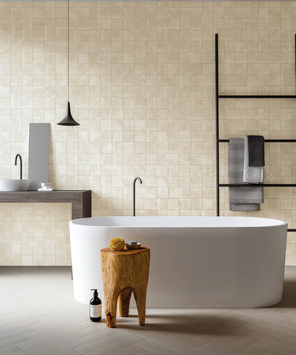 Modern bathroom with a freestanding bathtub, wooden stool, and tiled walls.