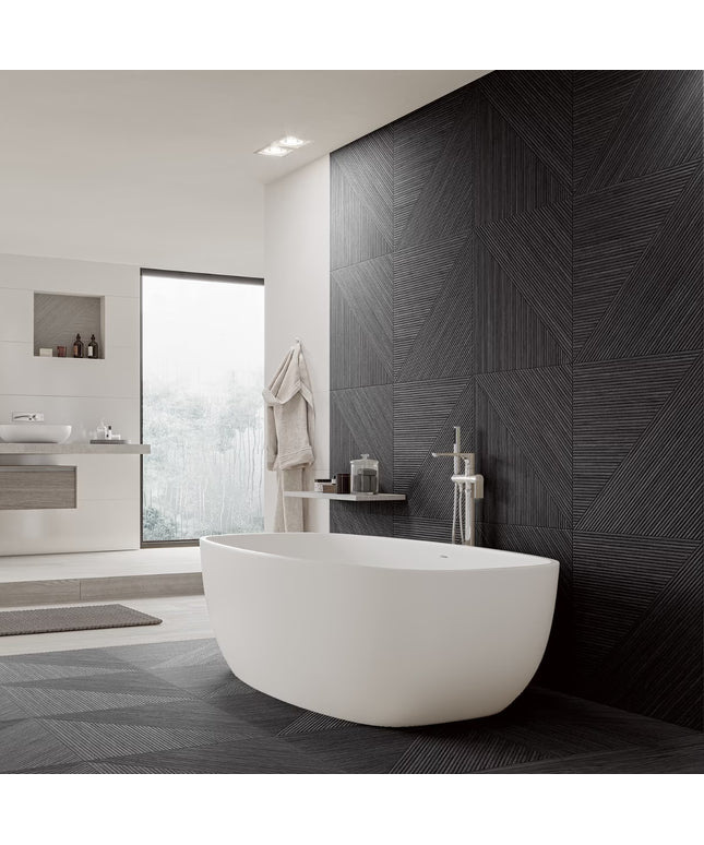 Modern bathroom with a freestanding white bathtub against a dark patterned wall.