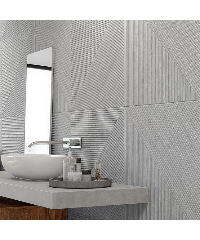 Bathroom with gray textured tiles, sink, and mirror.