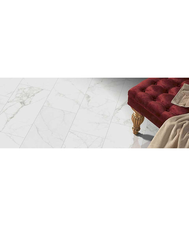 Marble floor with a red cushioned ottoman and beige rug.