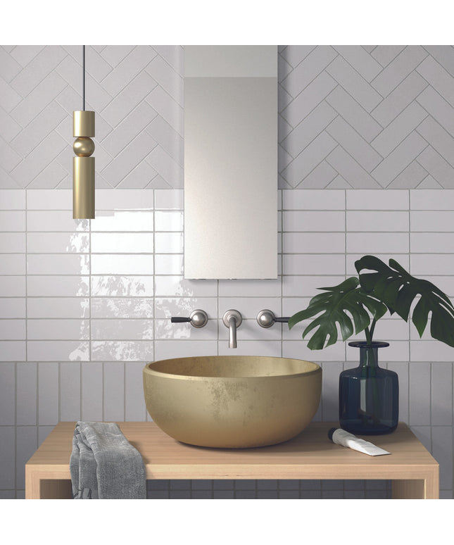 Modern bathroom vanity with beige vessel sink, glossy white wall tiles, and herringbone backsplash.