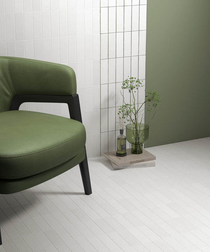 Modern room with matte white floor tiles, green accent wall, and green chair
