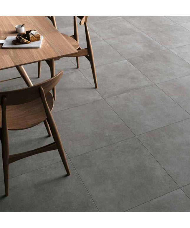 Modern dining area with large gray porcelain floor tiles and wooden table chairs