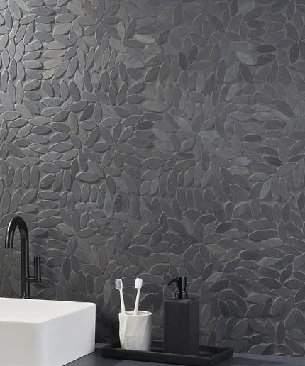 Black floral leaf mosaic tile backsplash in modern bathroom with matte sink and faucet