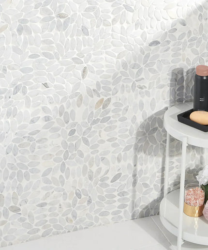 flower carrara natural stone mosaic tiles on bathroom wall with white shelf and toiletries