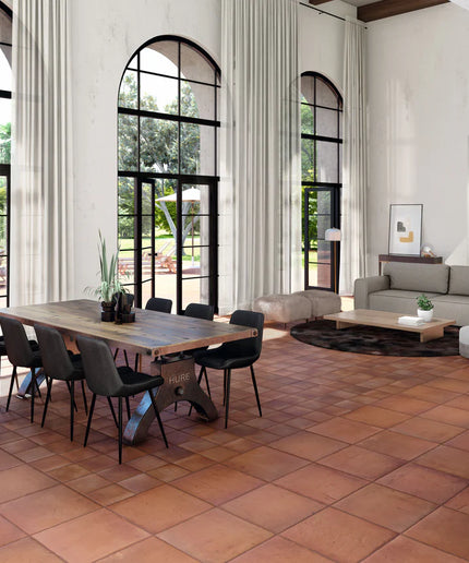 Modern living room with a dining table and chairs, large windows, and a sofa.