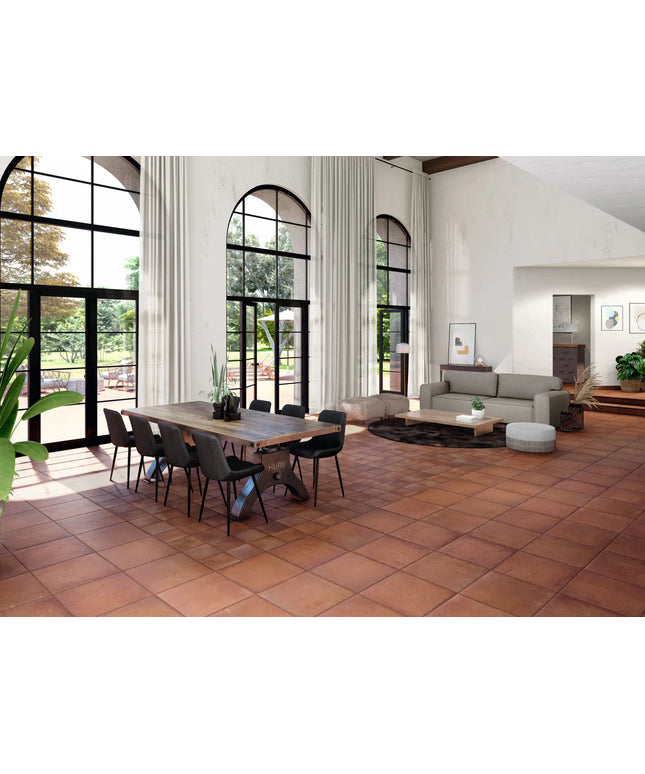 Modern living room with a dining table and chairs, large windows, and a sofa.