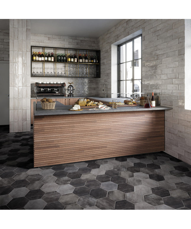 Modern kitchen with wooden bar counter, stone walls, and hexagonal floor tiles.