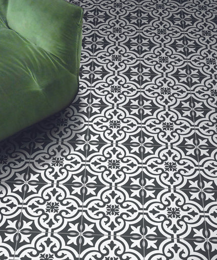 Black and white decorative floor tiles with a green velvet armchair