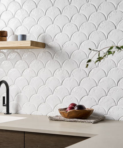 Modern kitchen with white scalloped tile backsplash, wooden countertop, and black faucet.