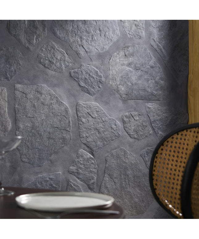 Close-up of a stone-textured wall with a plate and chair in the foreground