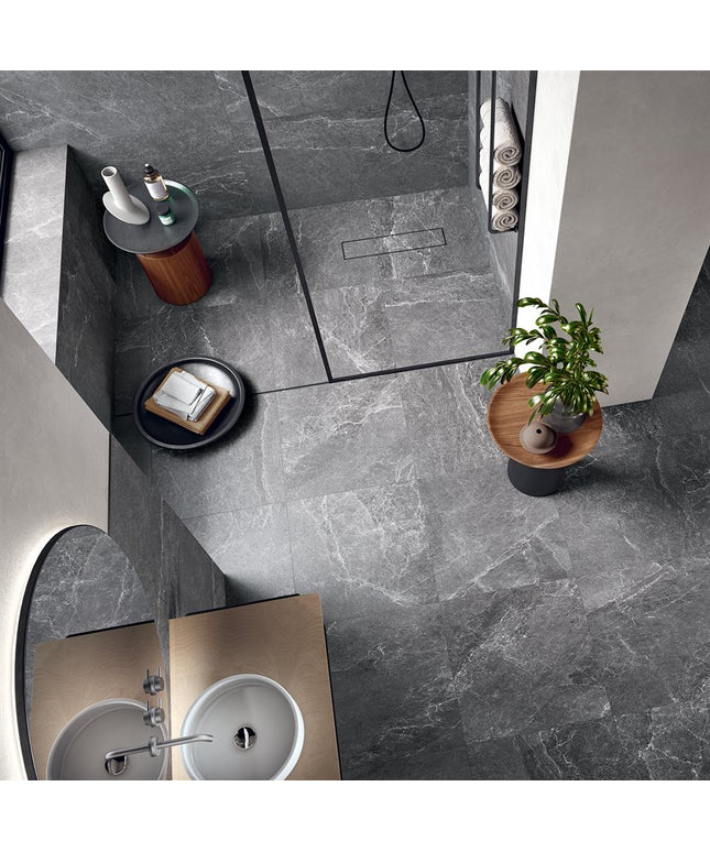 Modern bathroom with gray tiles, a sink, and decorative elements.