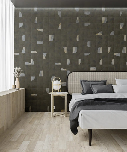 Modern bedroom with geometric patterned wall, bed, and side table.