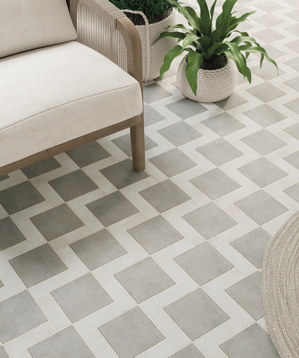 Patterned tile floor with a chair and plants in an outdoor setting