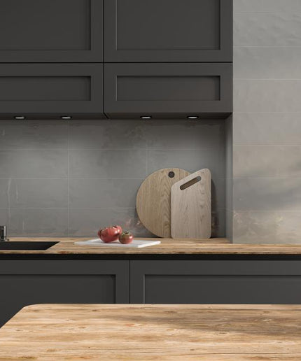 Modern kitchen with dark cabinets, wooden countertops, and a tiled backsplash.