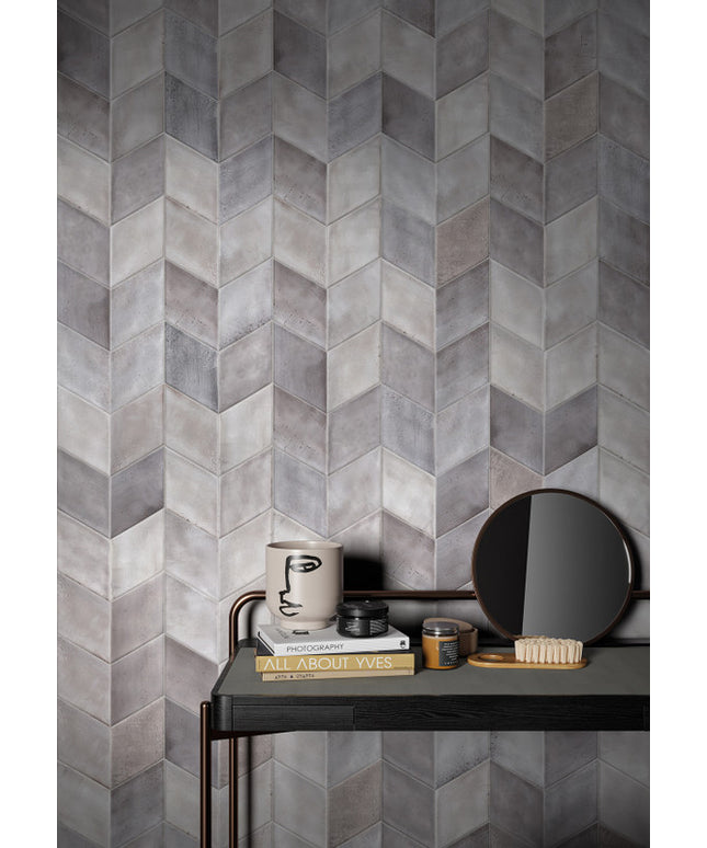 Gray tiled wall with a small table and decorative items in front
