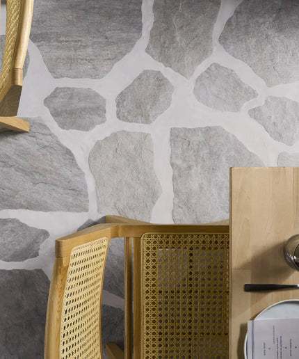 Gold chair and table with stone-patterned wall in the background