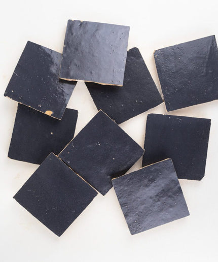 Nine black square tiles on a white background