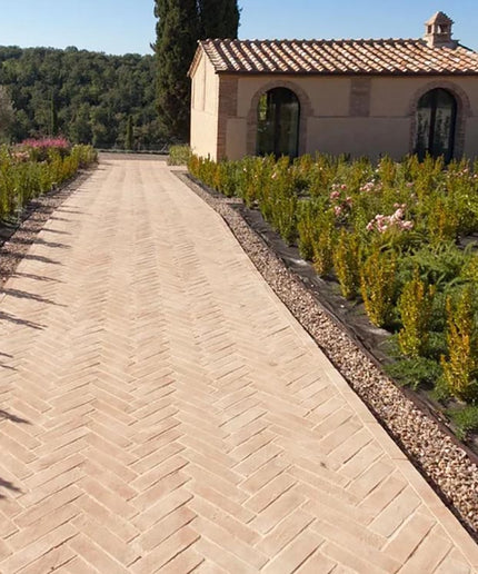 Italian terracotta tiles in herringbone pattern on outdoor garden pathway with villa