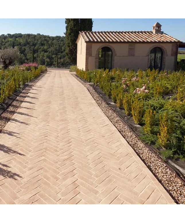 Italian terracotta tiles in herringbone pattern on outdoor garden pathway with villa