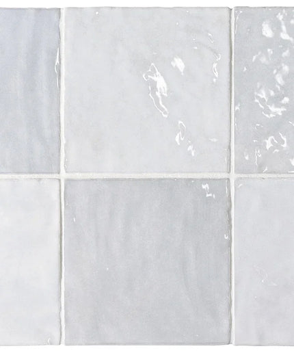 Set of six white ceramic tiles with subtle patterns on a white background