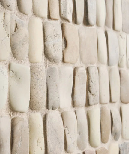 Close-up of a textured stone wall with beige and brown tones.