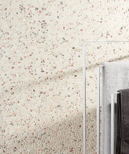 Textured pebble stone wall tiles in neutral colors behind towel rack