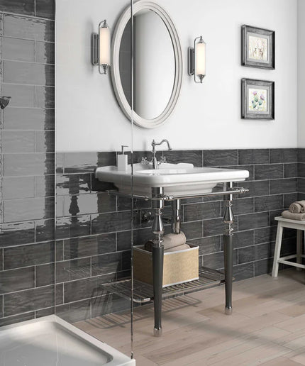 Modern bathroom with glossy dark gray subway wall tiles, white sink, and open shower area