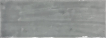 Glossy gray subway tile with a slightly wavy surface, ideal for kitchen backsplash or bathroom walls.