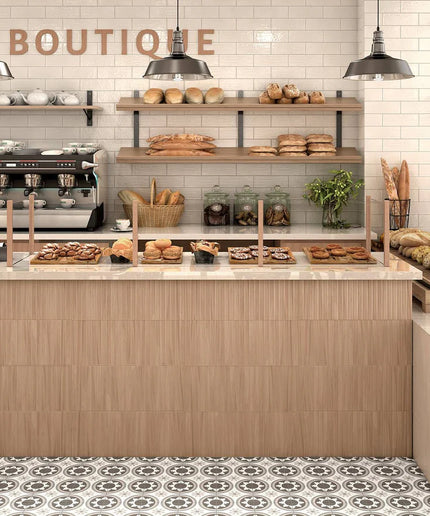 Modern bakery interior with glossy beige subway tile walls and patterned tile flooring