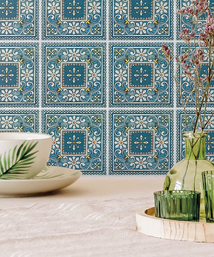Blue floral patterned wall tiles with decorative glass vases and a cup on a light surface