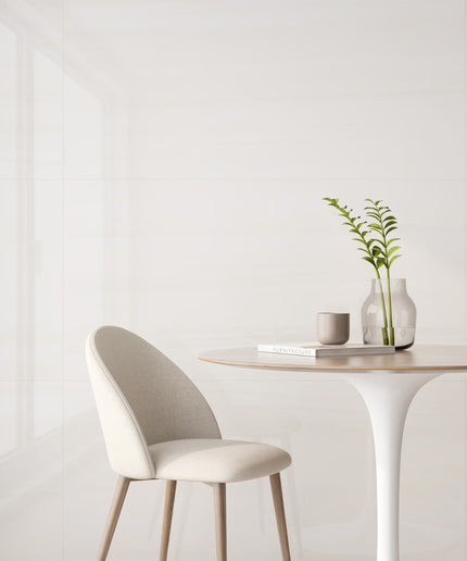 Modern chair and table setup with a plant and books on a white background