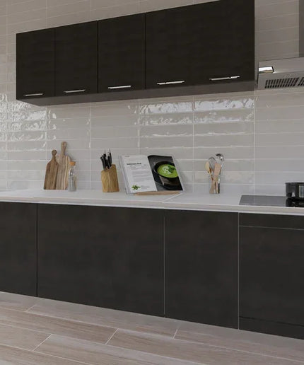 Glossy white wall tile backsplash in modern kitchen with dark cabinets and wood-look floor.