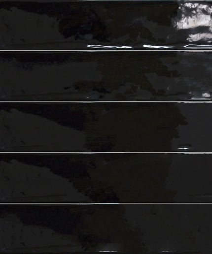 Glossy black rectangular tiles with a wavy textured surface, ideal for modern walls or backsplash.