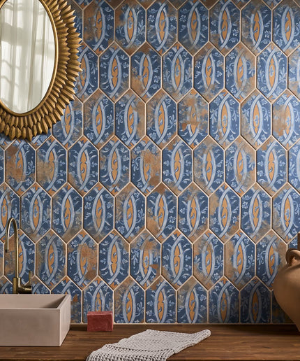 Decorative blue and gold hexagonal tiles on a wall with a mirror and vase in the foreground.