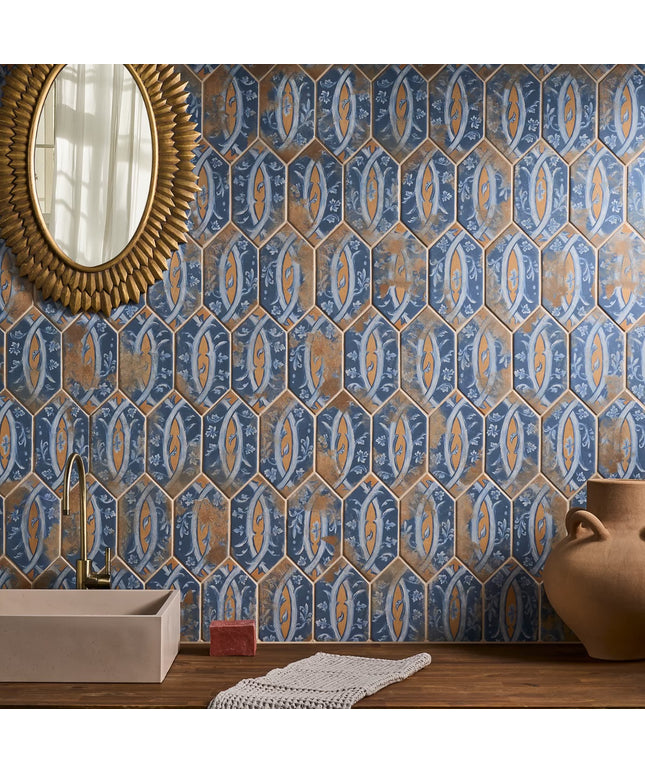 Decorative blue and gold hexagonal tiles on a wall with a mirror and vase in the foreground.